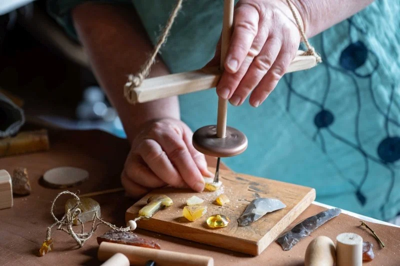 A demonstration of a traditional tool that makes holes in amber pieces to make jewellery 