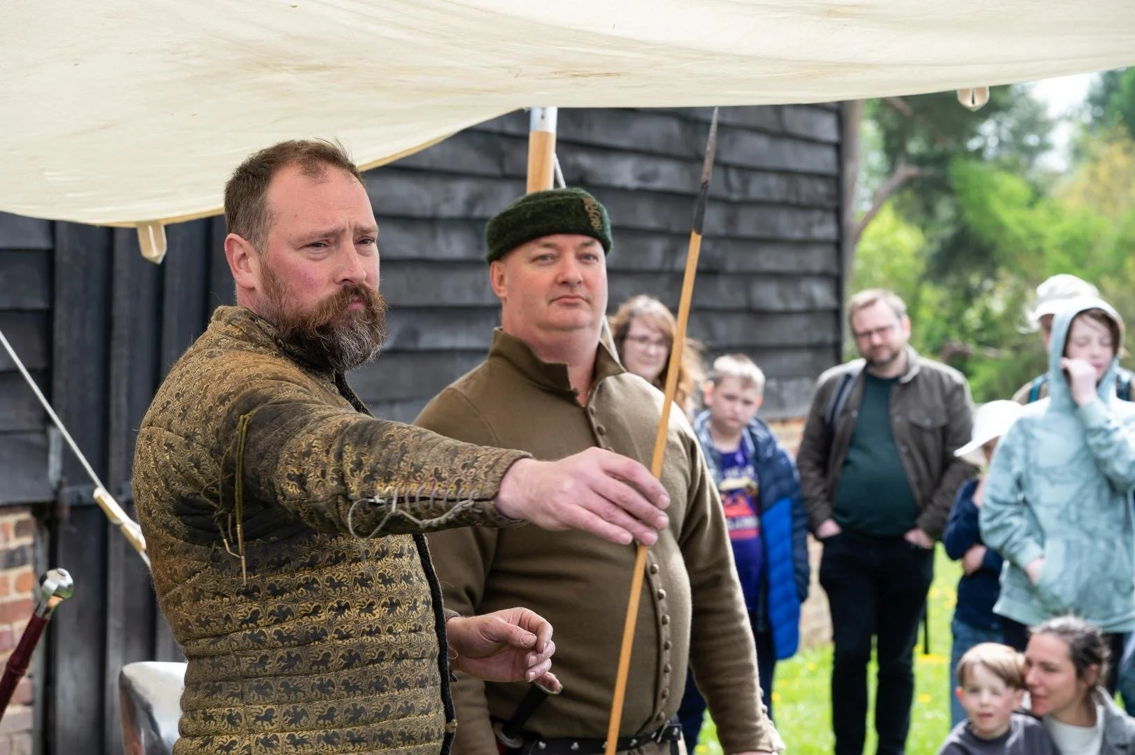 Two men dressed as medieval knights  - one is holding a spear