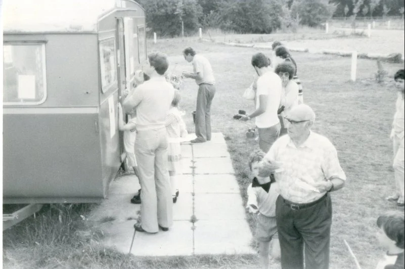 People stood outside ticket office caravan