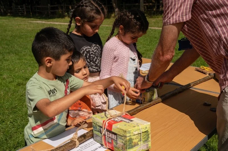 Three children practicing tying knots