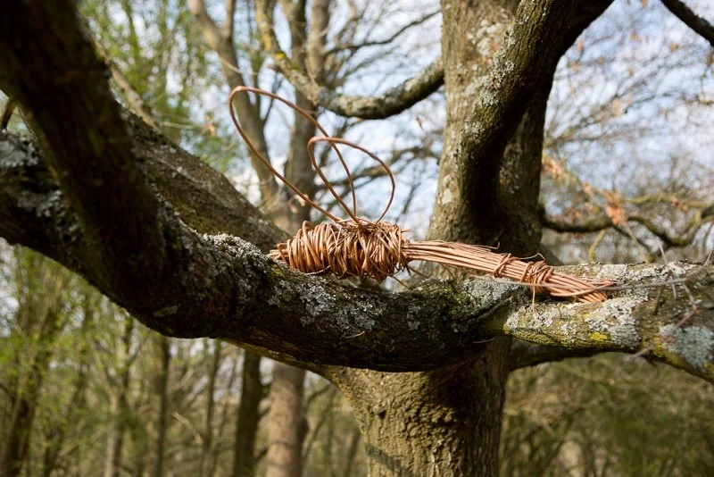 A willow dragonfly sculpture sitting on a tree branch