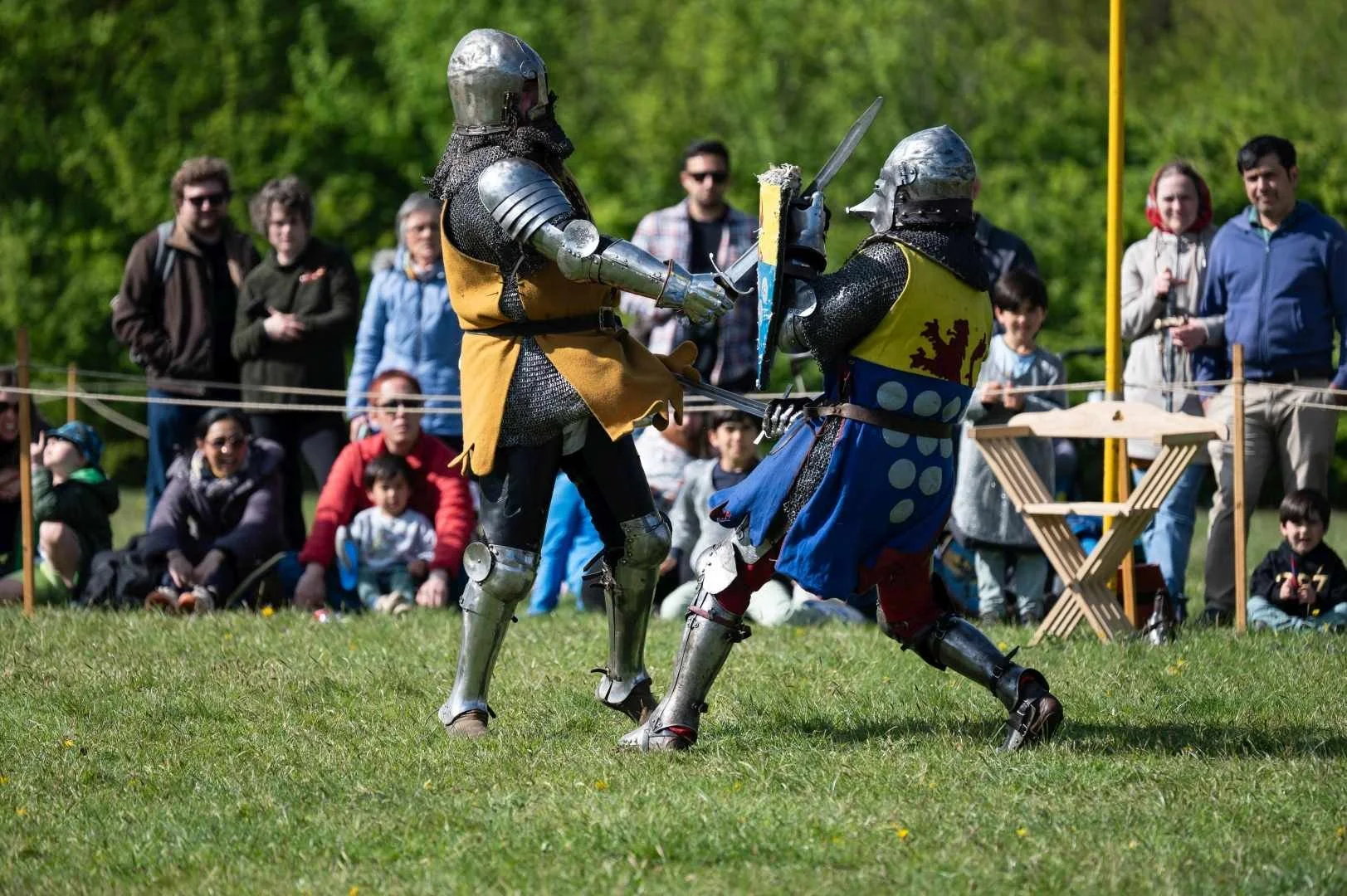 Two medieval knights in armour fighting with swords and shields