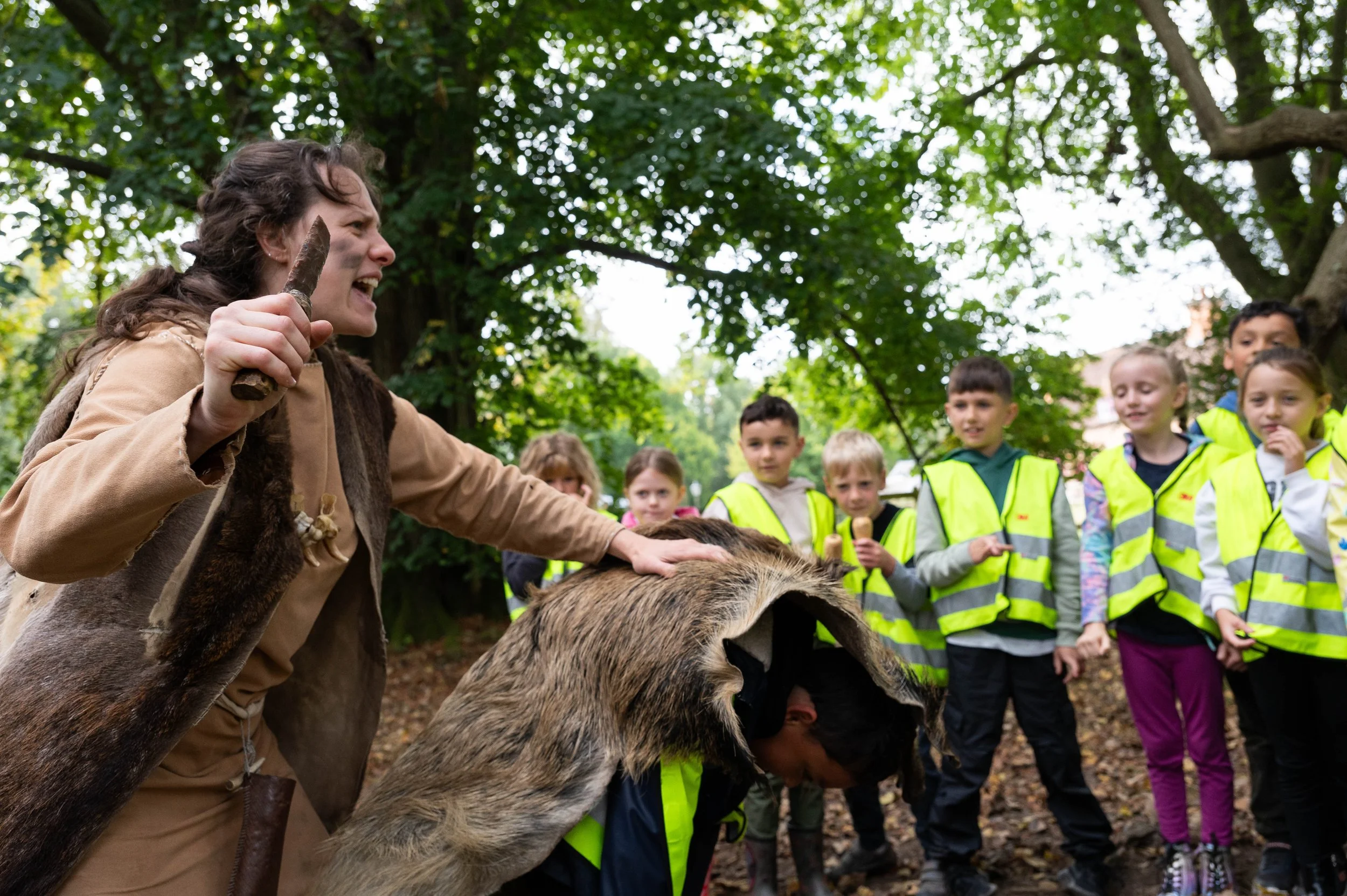 A stone age warrior teaching school children about the stone age in a workshop at COAM