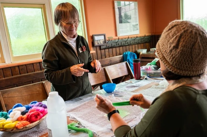A smiling lady demonstrates how to do wet felting