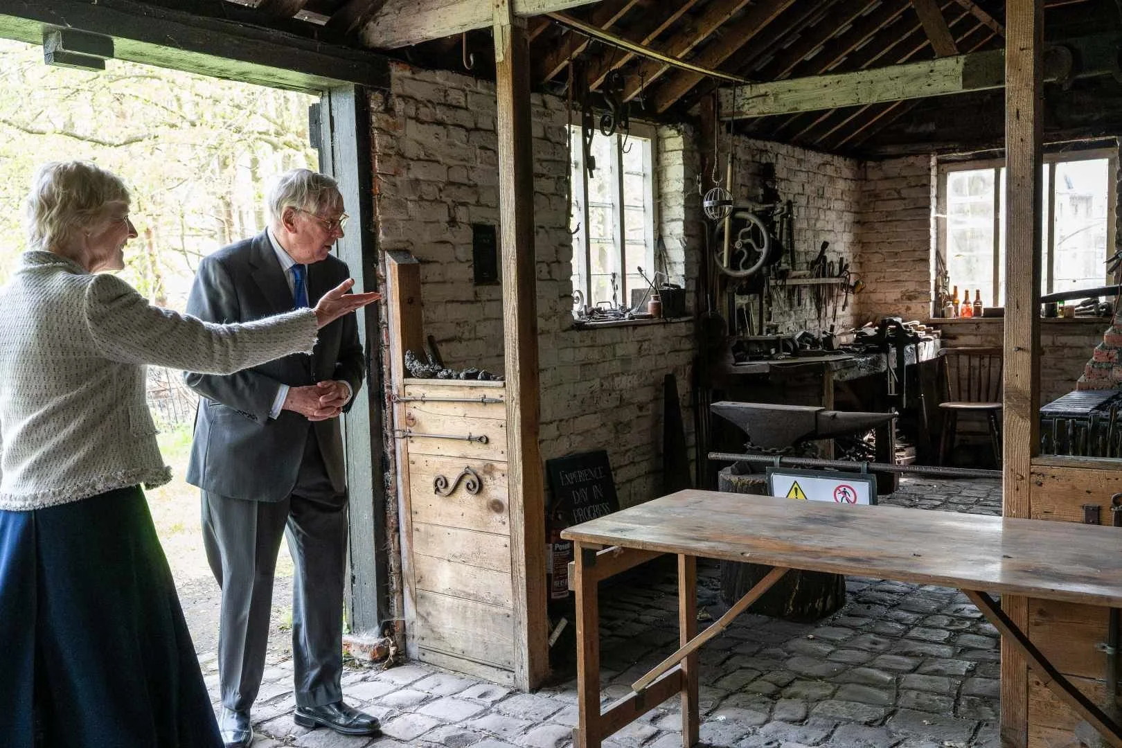 HRH The Duke of Gloucester alongside alongside the Lord-Lieutenant of Buckinghamshire in the blacksmiths forge at Chiltern Open Air Museum