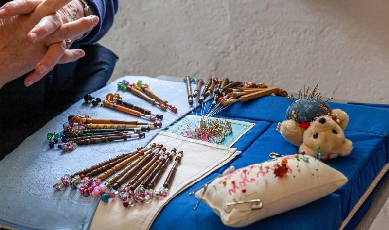 Making lace using wooden bobbins 