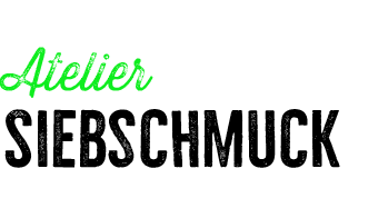 Texto en verde que dice 'Atelier' y en negro que dice 'Druckerei Fantasia' en un fondo claro.