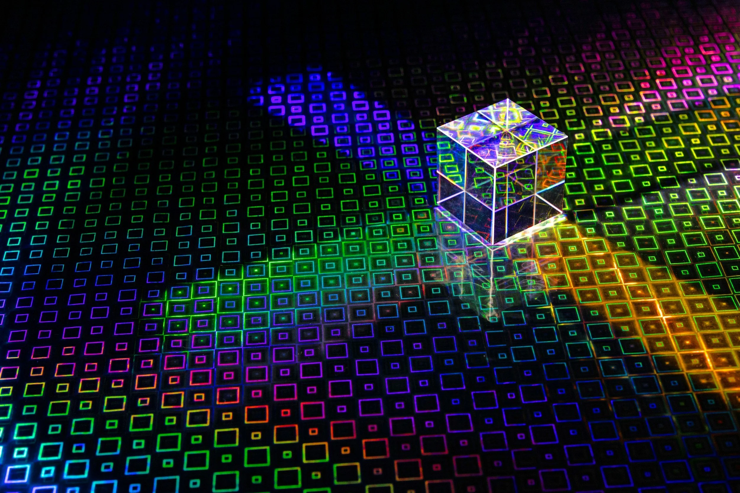 Colorful digital hologram of a cube and grid patterns on a black background.