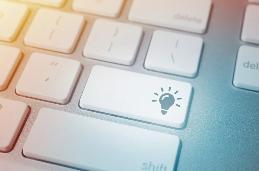 Close-up of a computer keyboard with a white key featuring a light bulb icon.