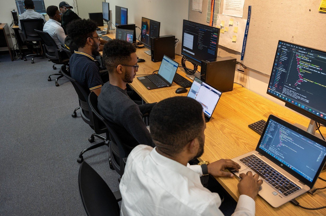 Pictured are students sitting at desks on their laptops