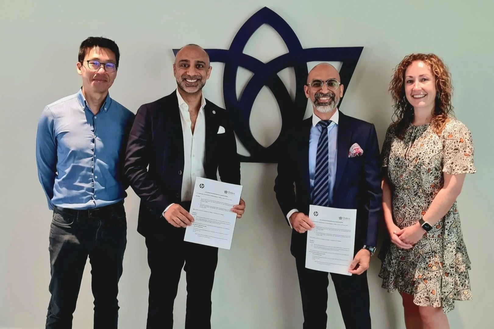 editorial image showing representatives from HP and Dukes Education holding signed agreement documents. The image relates to HP’s agreement to introduce its NOVA AI capacity-building fellowship for teachers