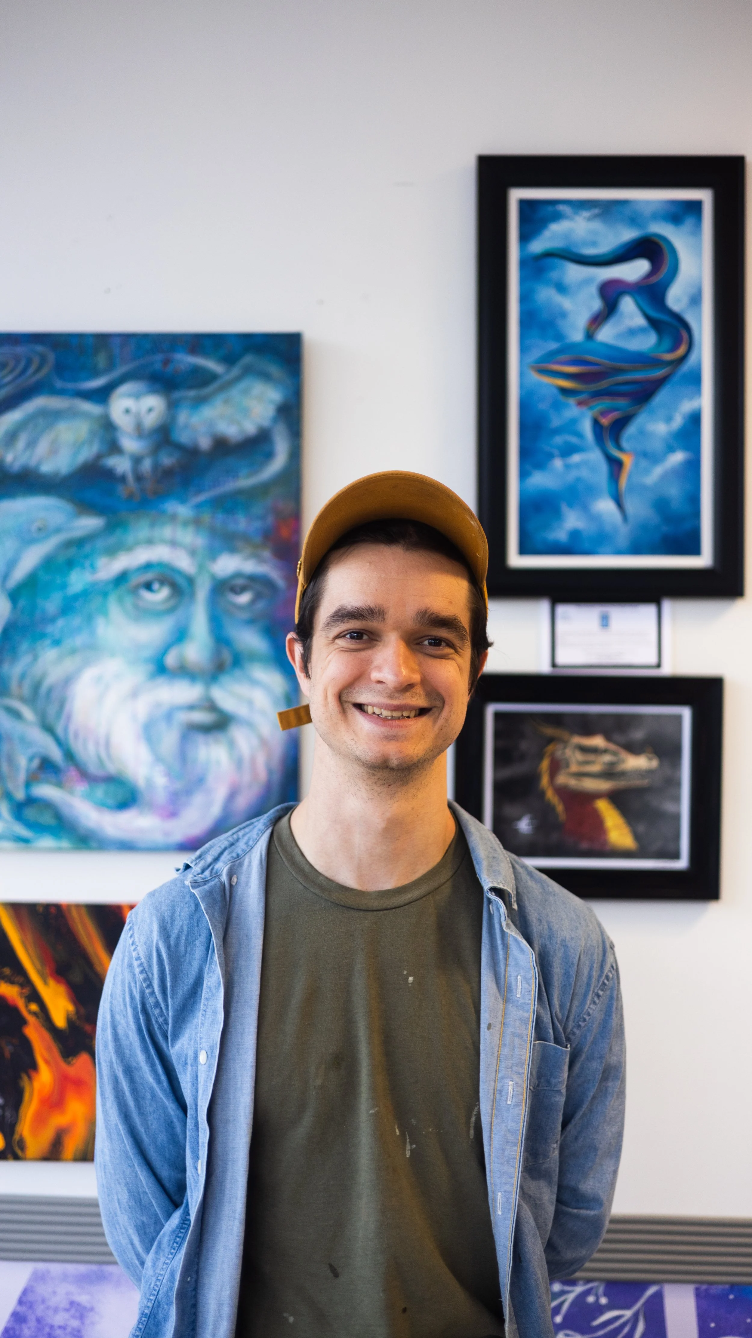 Founder of Consciousness Coffee, Jason Rounds, stands in front of locally made art being displayed at the coffee shop.