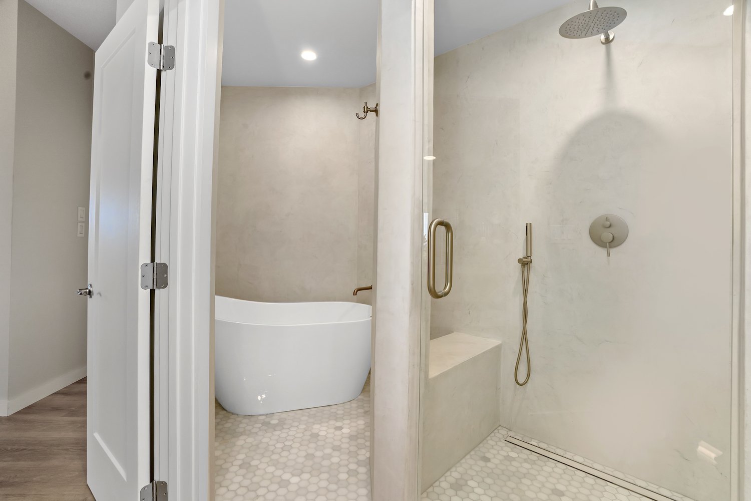 Modern bathroom with a separate walk-in shower and a bathtub, featuring minimalistic design, neutral colors, hexagon floor tiles, and brass fixtures.