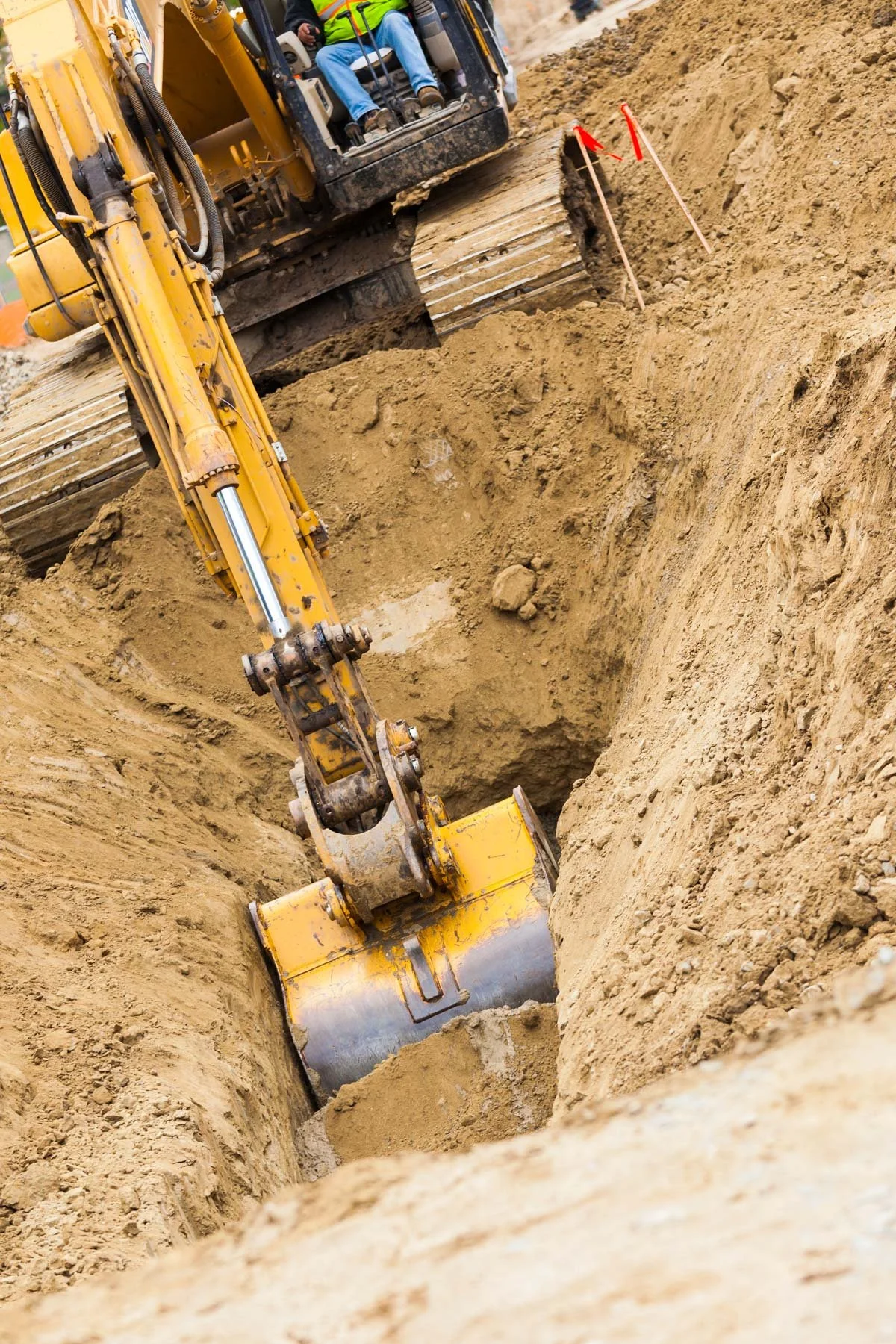 Excavator digging a trench at a construction site.