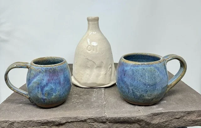 two ceramic mugs and an oil jar