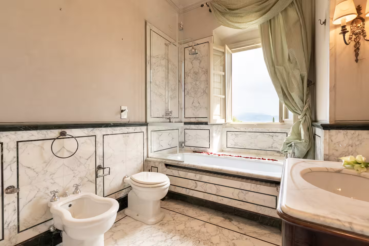 Baño de mármol con bañera con vistas a las colinas: un rincón de spa privado de tus sueños.
