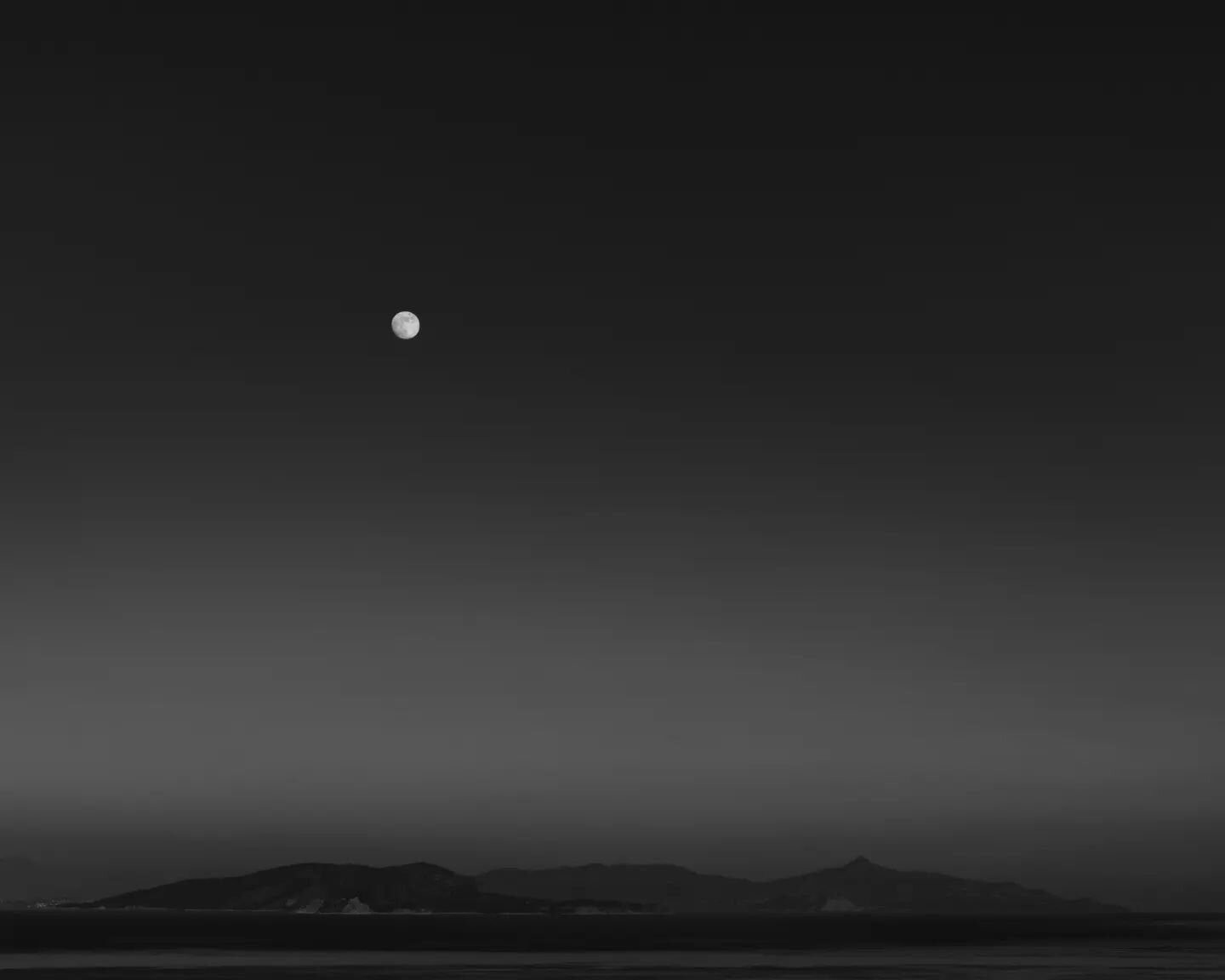 The waxing gibbous moon is rising behind the islands of Agistri and Aegina at the Saronic Gulf. The clear evening sky of the 25th of December was the reason why I had the opportunity to capture this minimalist shot. A calm evening without clouds and 