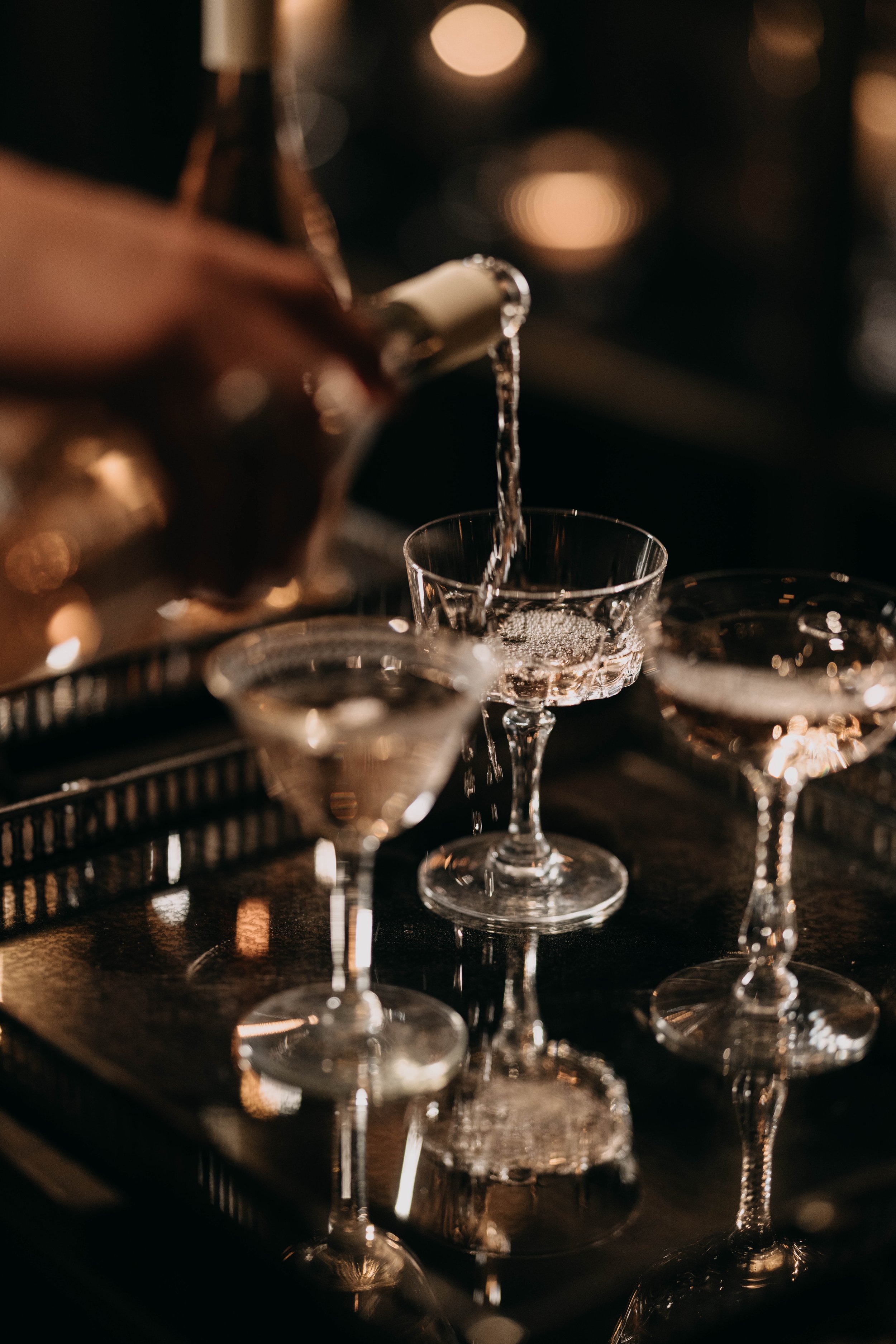 Champagne being poured into crystal glasses on a tray.