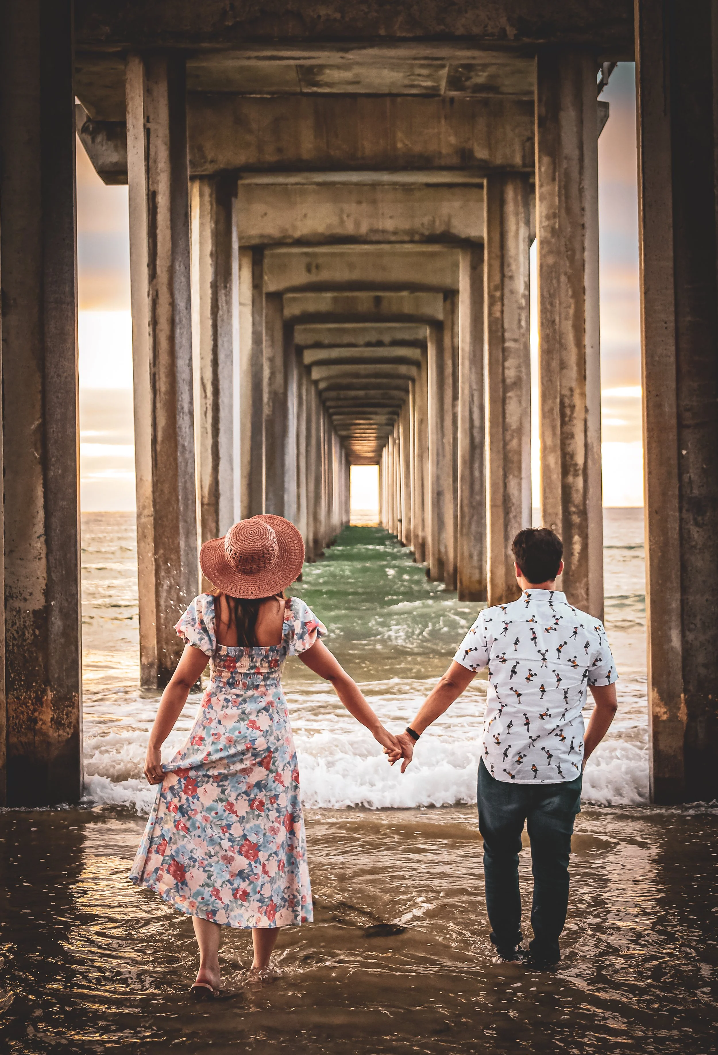 Couple holds hands at Ellen Browning Scripps Pier La Jolla, California