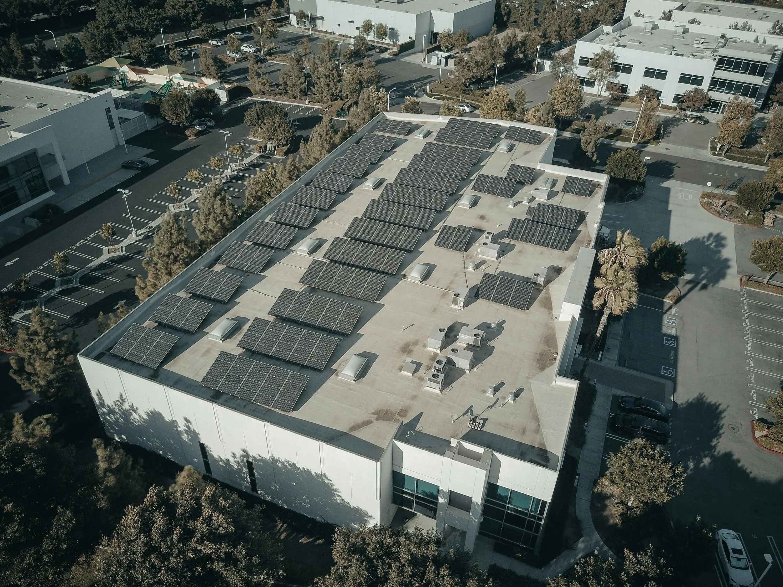 Solar panels installed on the rooftop of a low-rise building, generating renewable energy with the help of inverters.