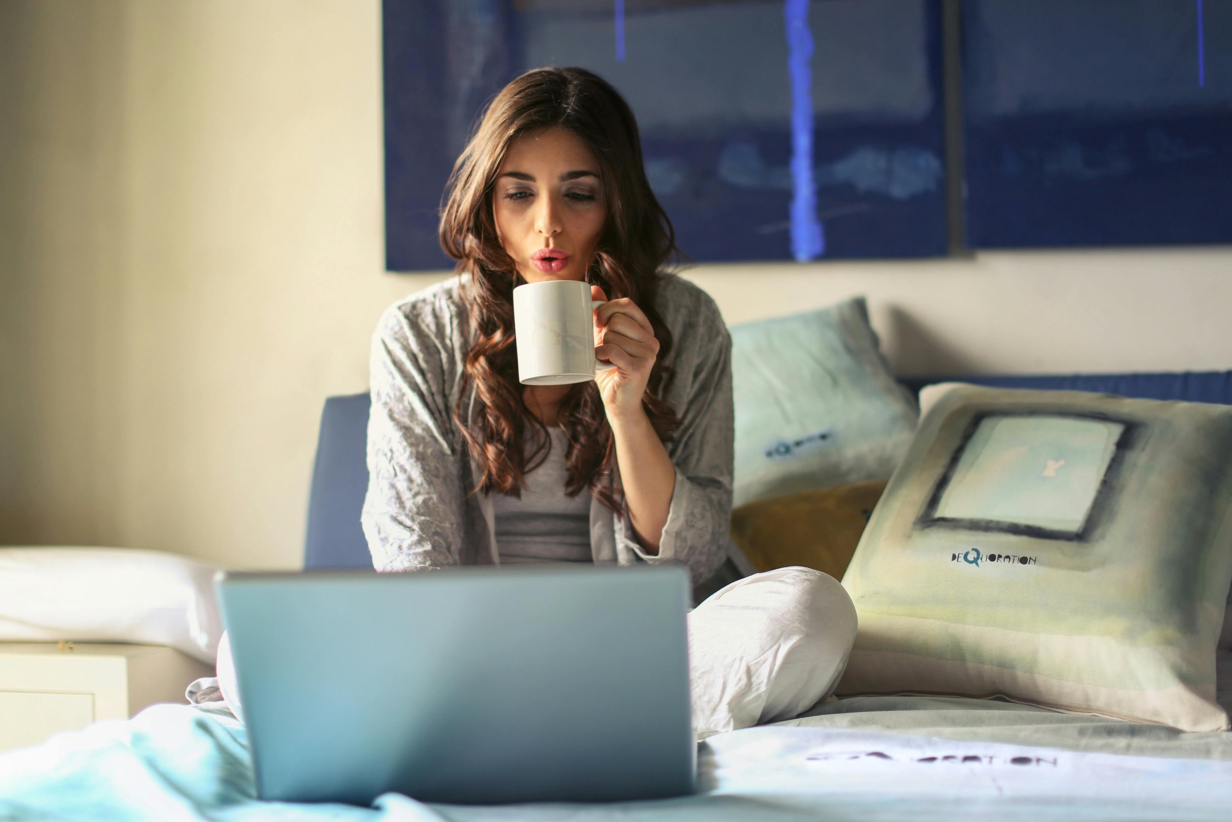 Woman starting her day with a cup of coffee and laptop, embracing a calm and focused morning routine.