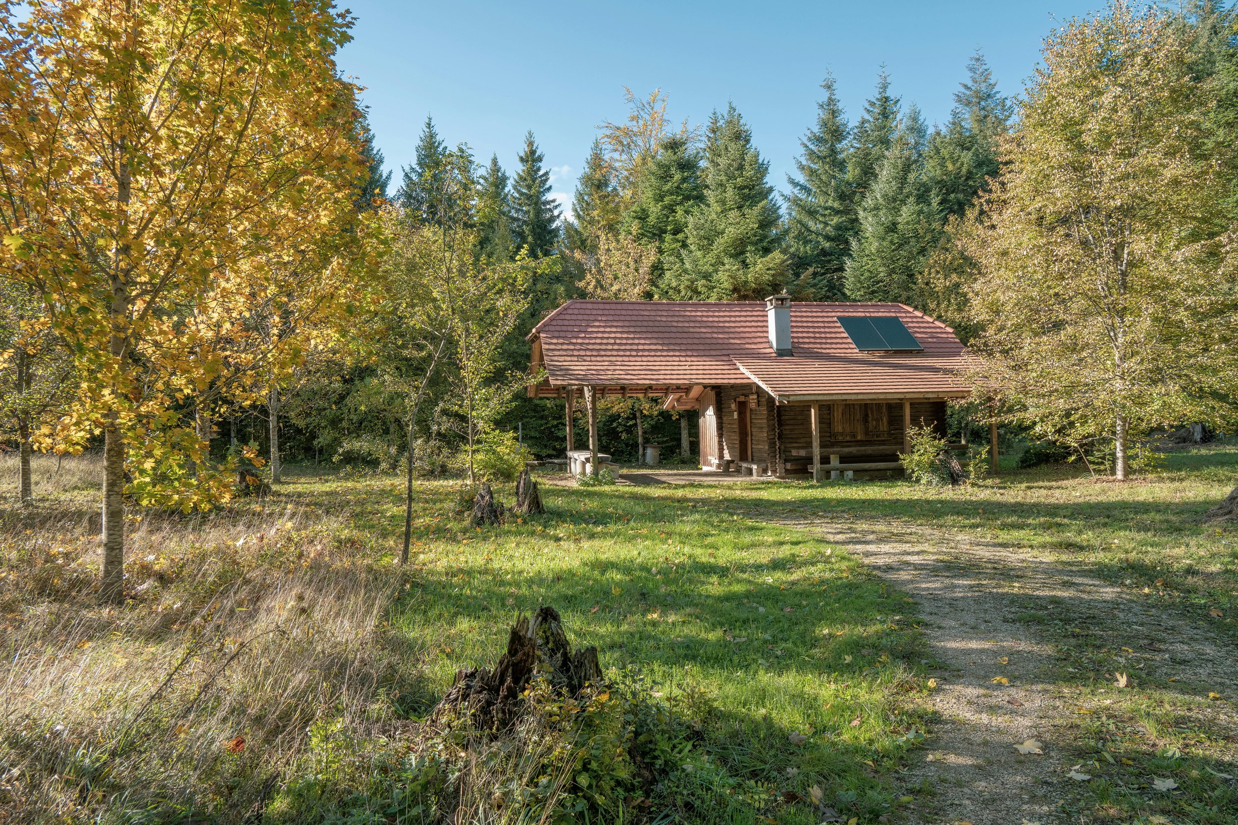 A remote house with solar panels installed on the roof, generating renewable energy from the sun.