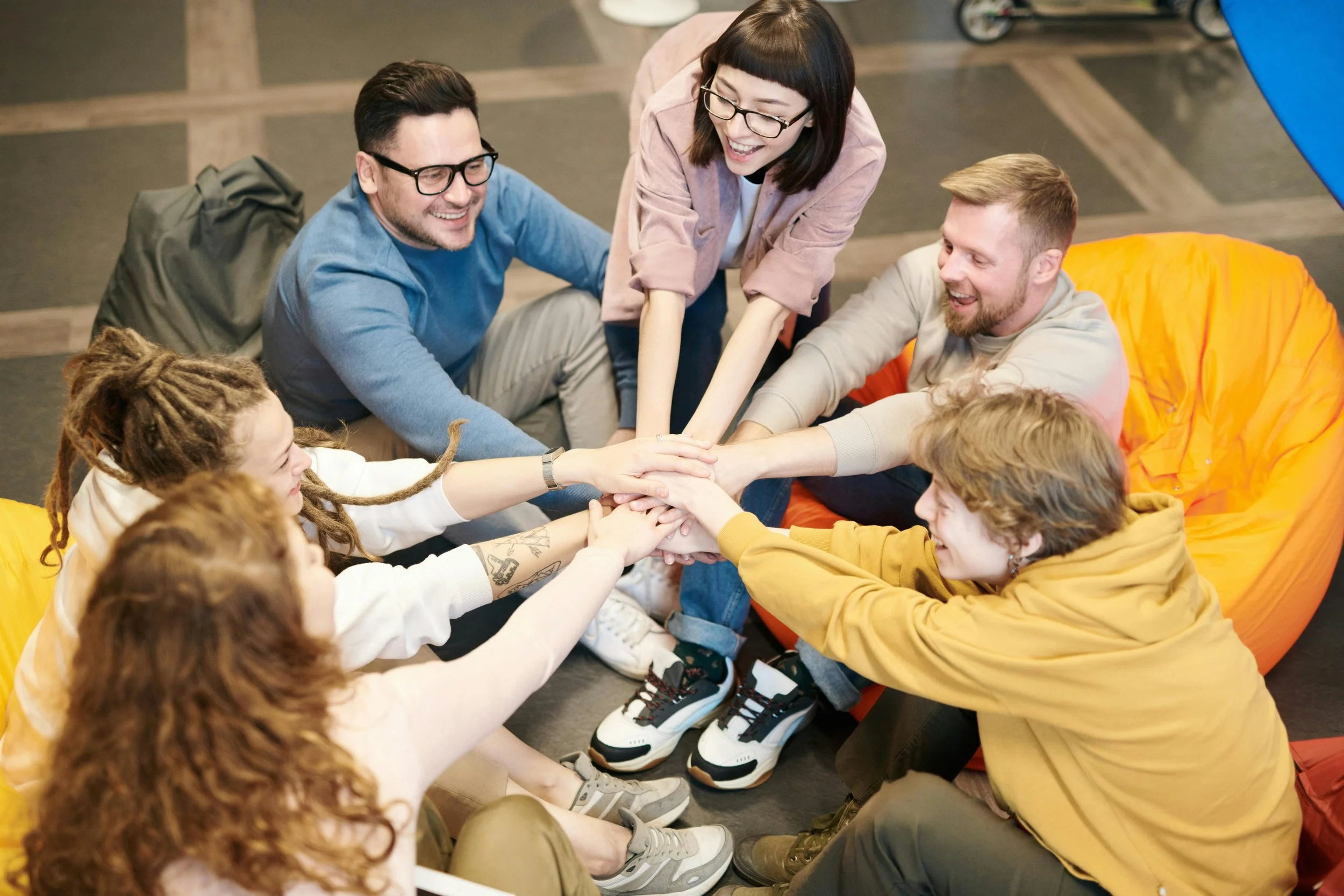 Happy, diverse team working together in a modern office, representing positive collaboration and effective leadership in action.