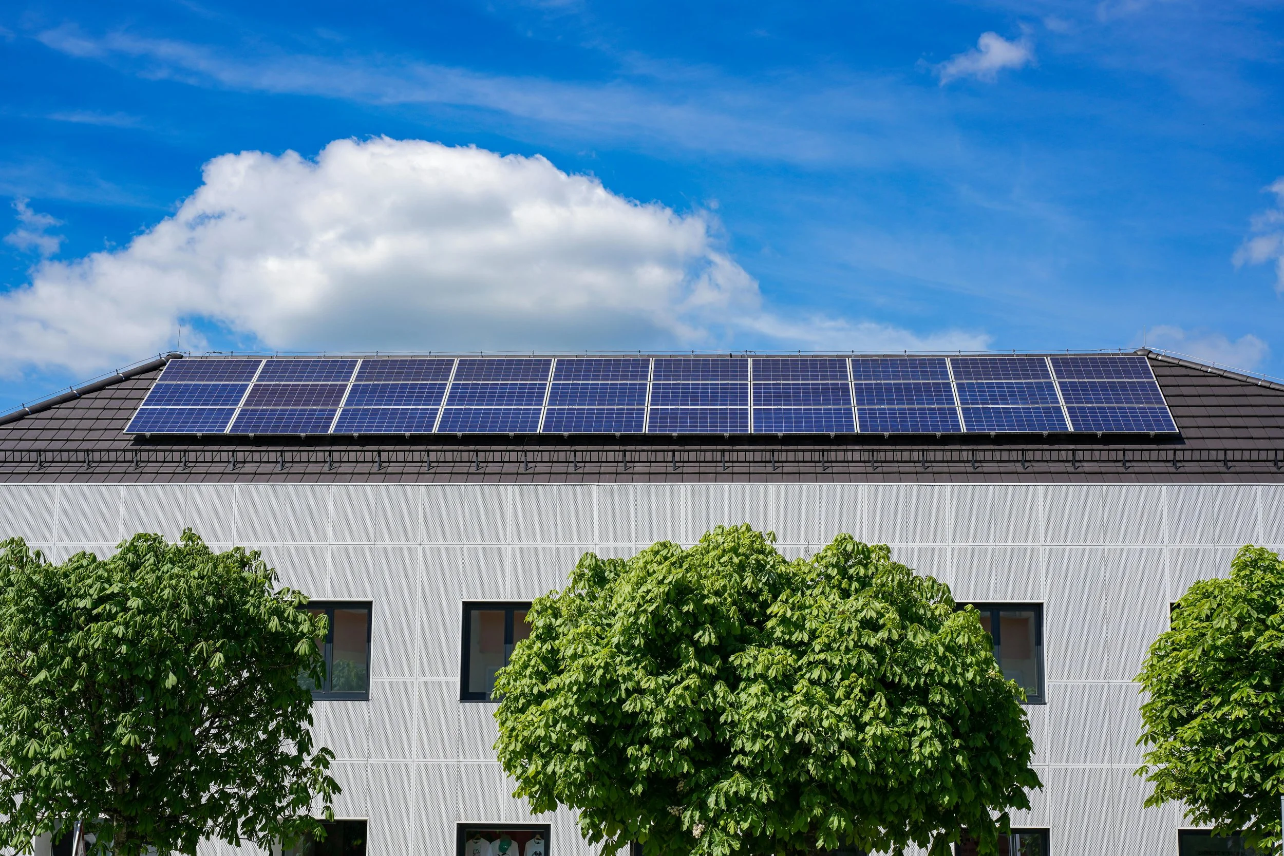 Modern building with rooftop solar panels representing the growth of clean and sustainable energy solutions.