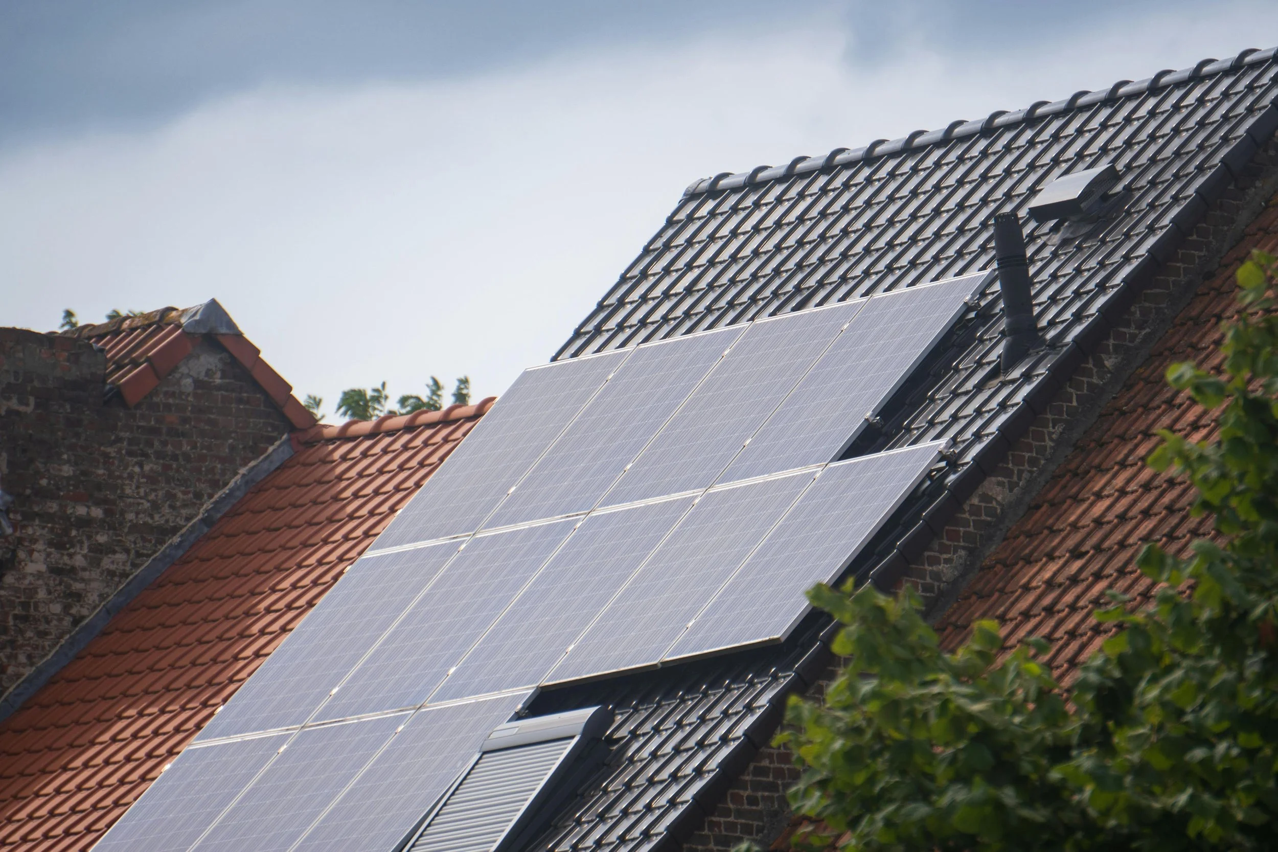 Rooftop solar panels installed on a modern residential house under clear blue sky