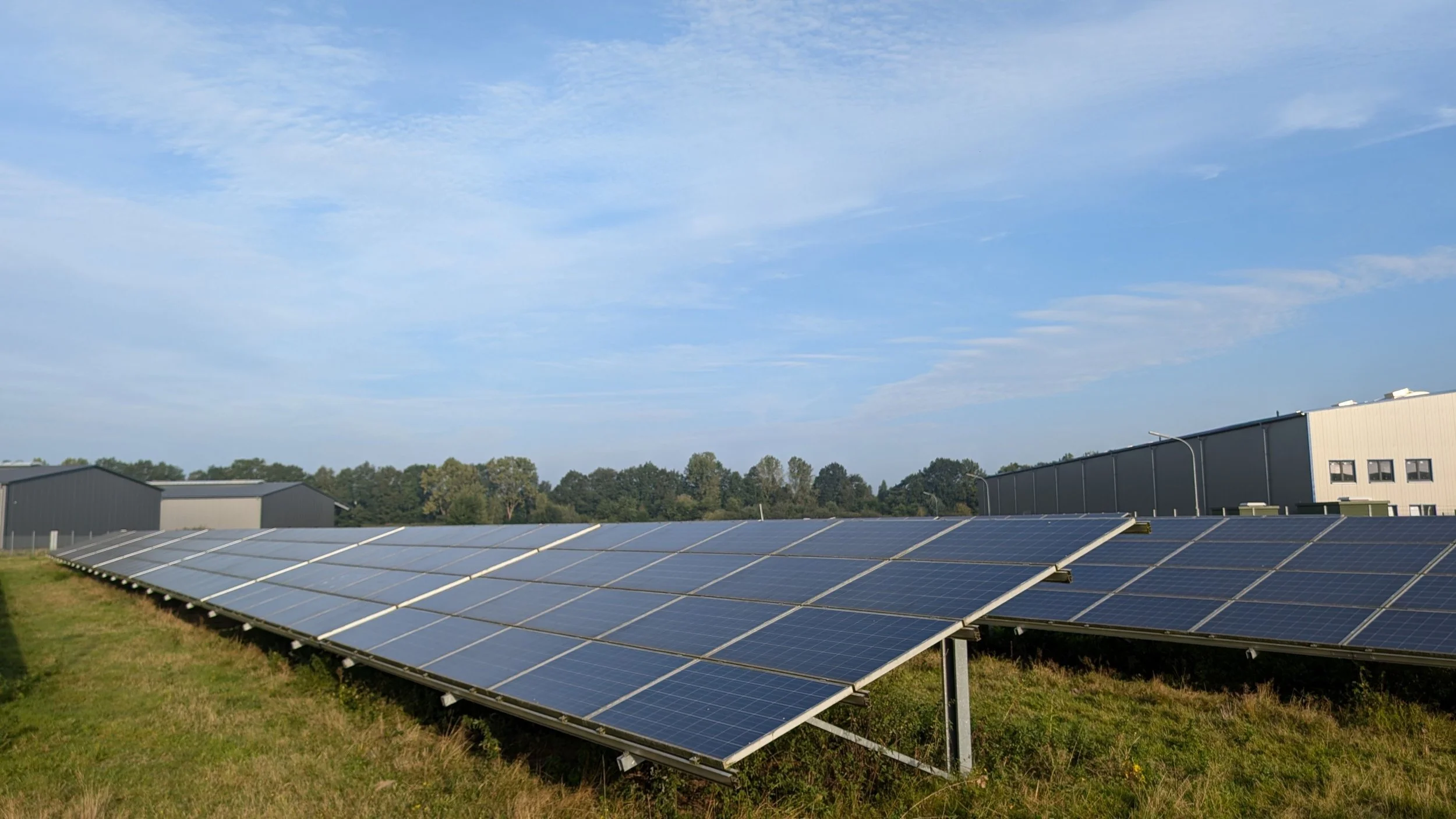 Solar panels installed in an open field under a clear blue sky, representing renewable energy generation and the measurement of solar system performance.