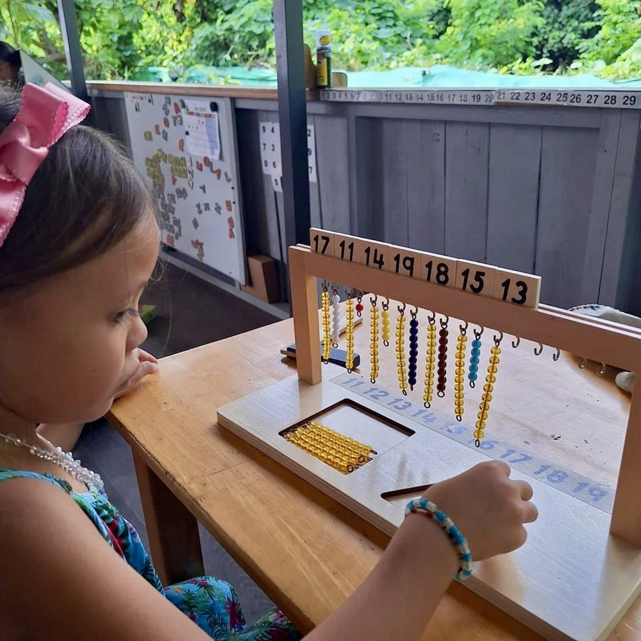 Enfant utilisant du matériel de mathématiques Montessori au Fare Anuanua