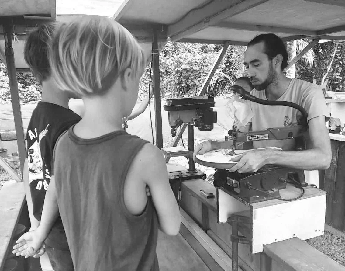 Fabrication d’objets en bois lors d’un atelier de menuiserie pour enfants organisé pendant les vacances scolaires à Fare Anuanua