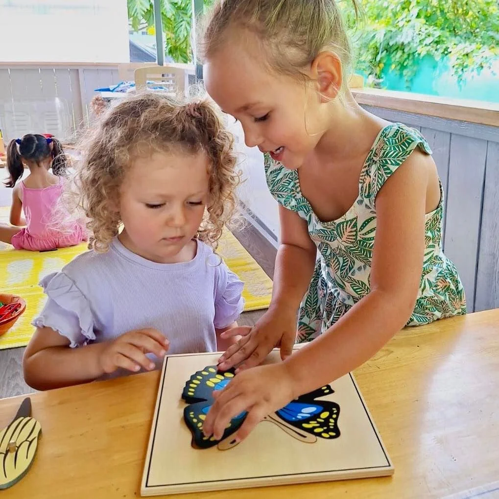 Deux élèves travaillant ensemble pour assembler un puzzle Montessori en forme de papillon à l’École Fare Anuanua à Moorea
