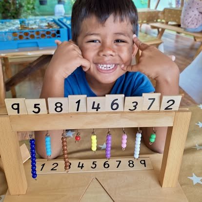 Enfant manipulant le matériel mathématique lors d'une activité Montessori à l’École Fare Anuanua à Moorea