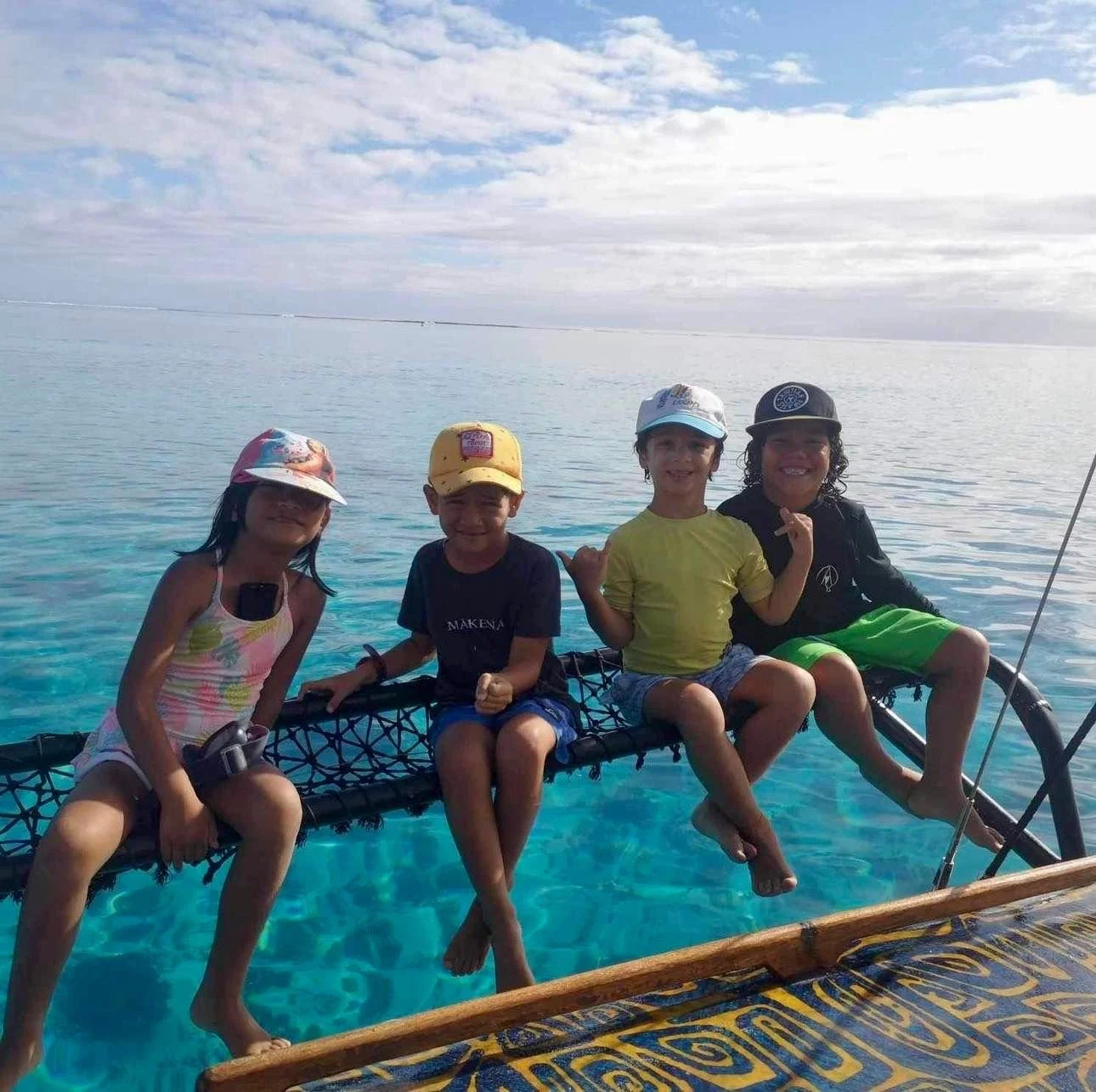 Enfants naviguant sur une pirogue à voile pendant les stages vacances organisés par l’École Fare Anuanua à Moorea