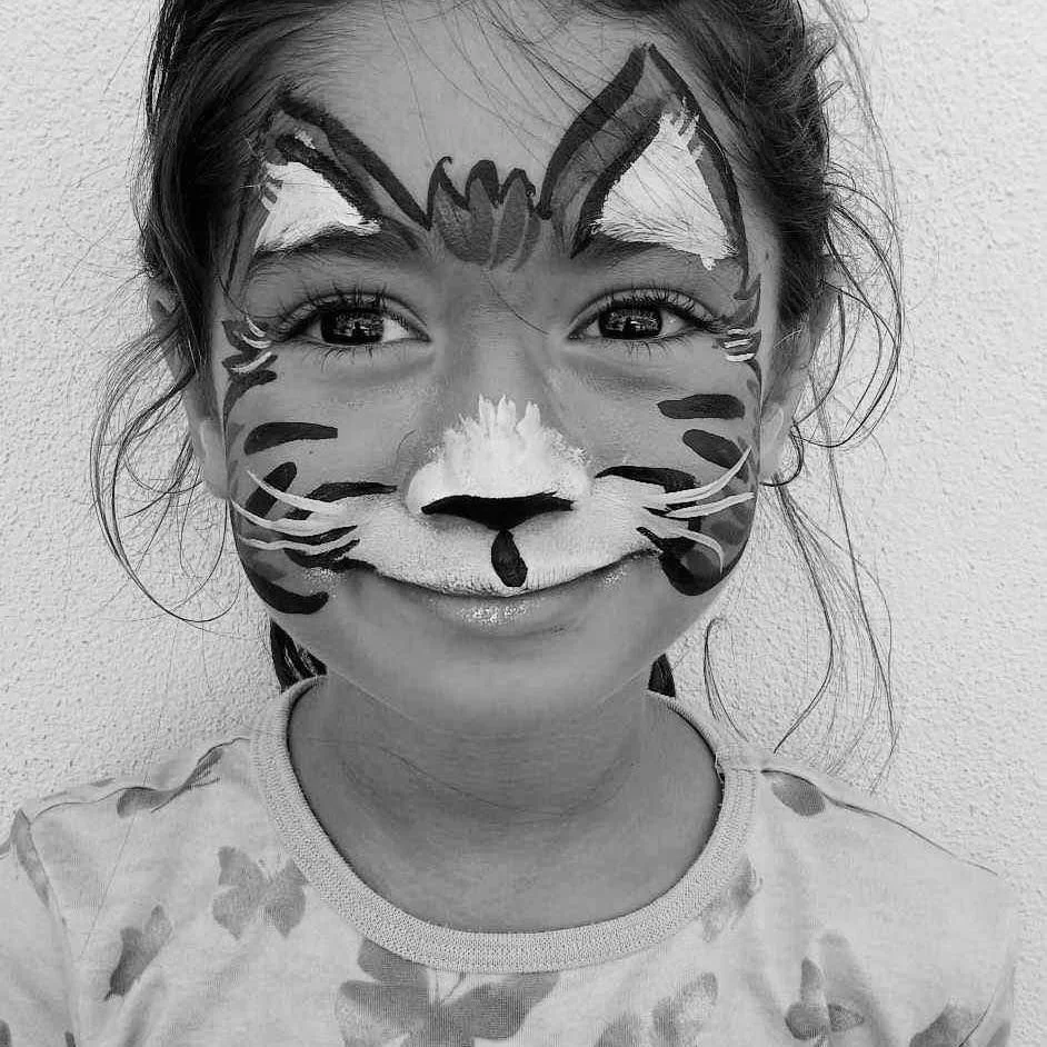 Enfant participant à un atelier ludique de maquillage pendant les vacances scolaires à l’École Fare Anuanua
