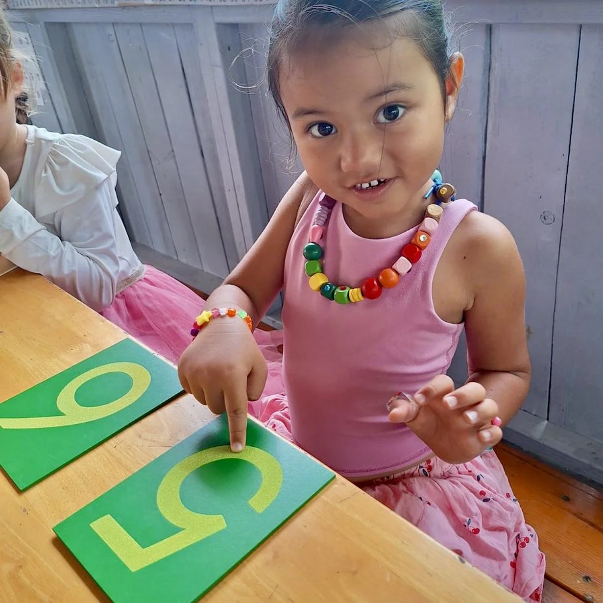 Enfant manipulant les chiffres rugueux lors d'une activité Montessori à l’École Fare Anuanua à Moorea