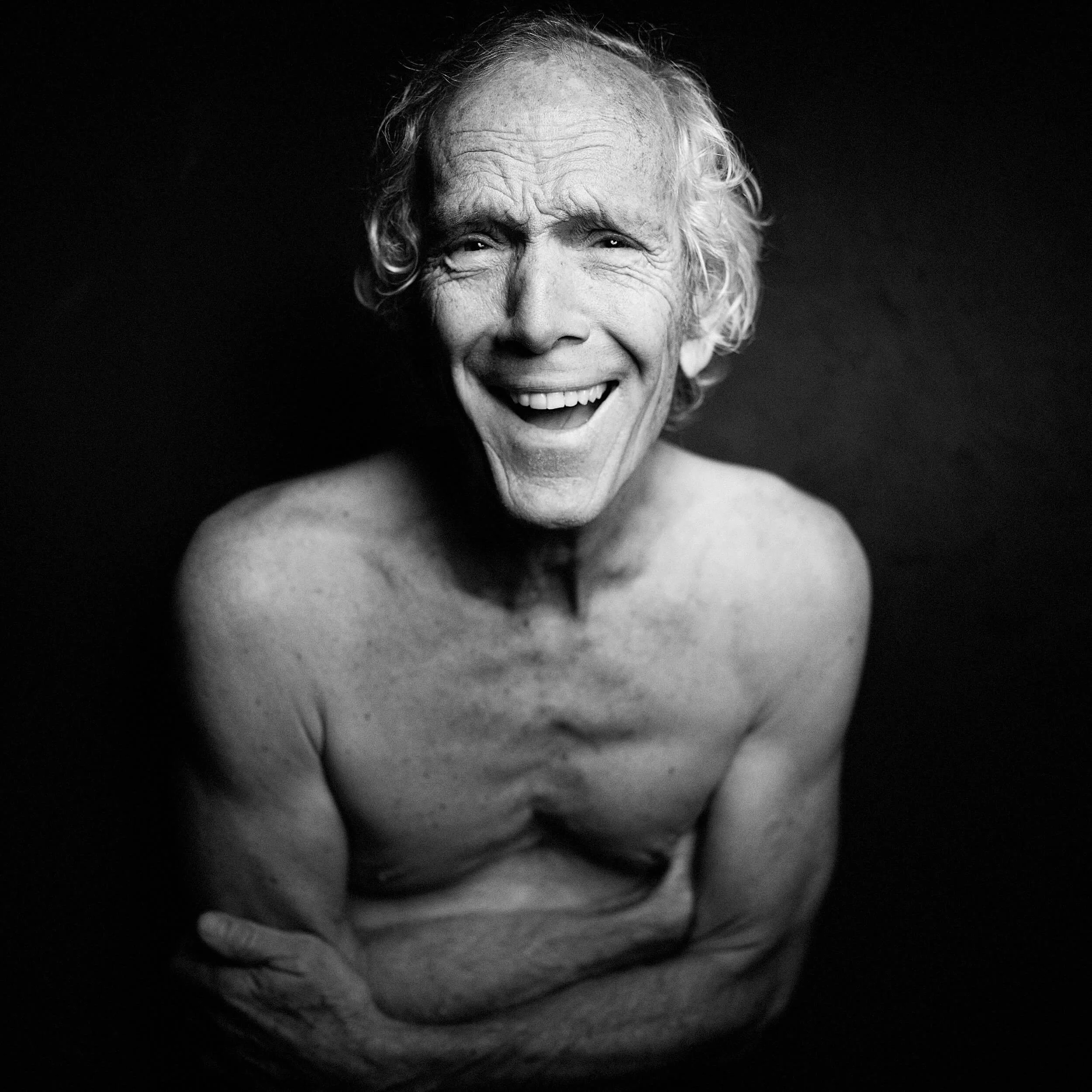Parker J Pfister Black and White Fine Art Portrait of olde white man without a shirt smiling at the camera
