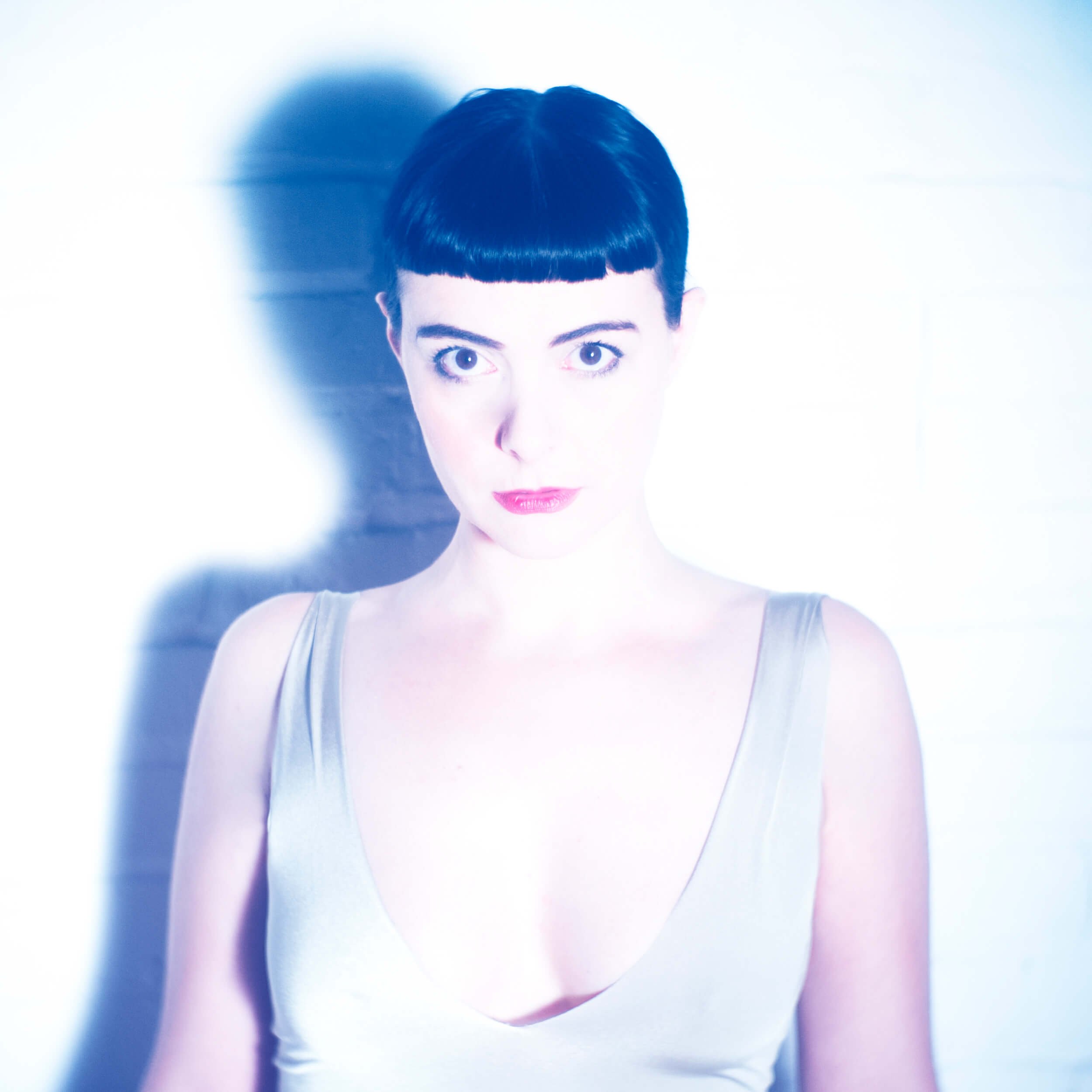 Parker J Pfister Fine Art Portrait of White woman with short bangs with lots of light looking straight at camera.