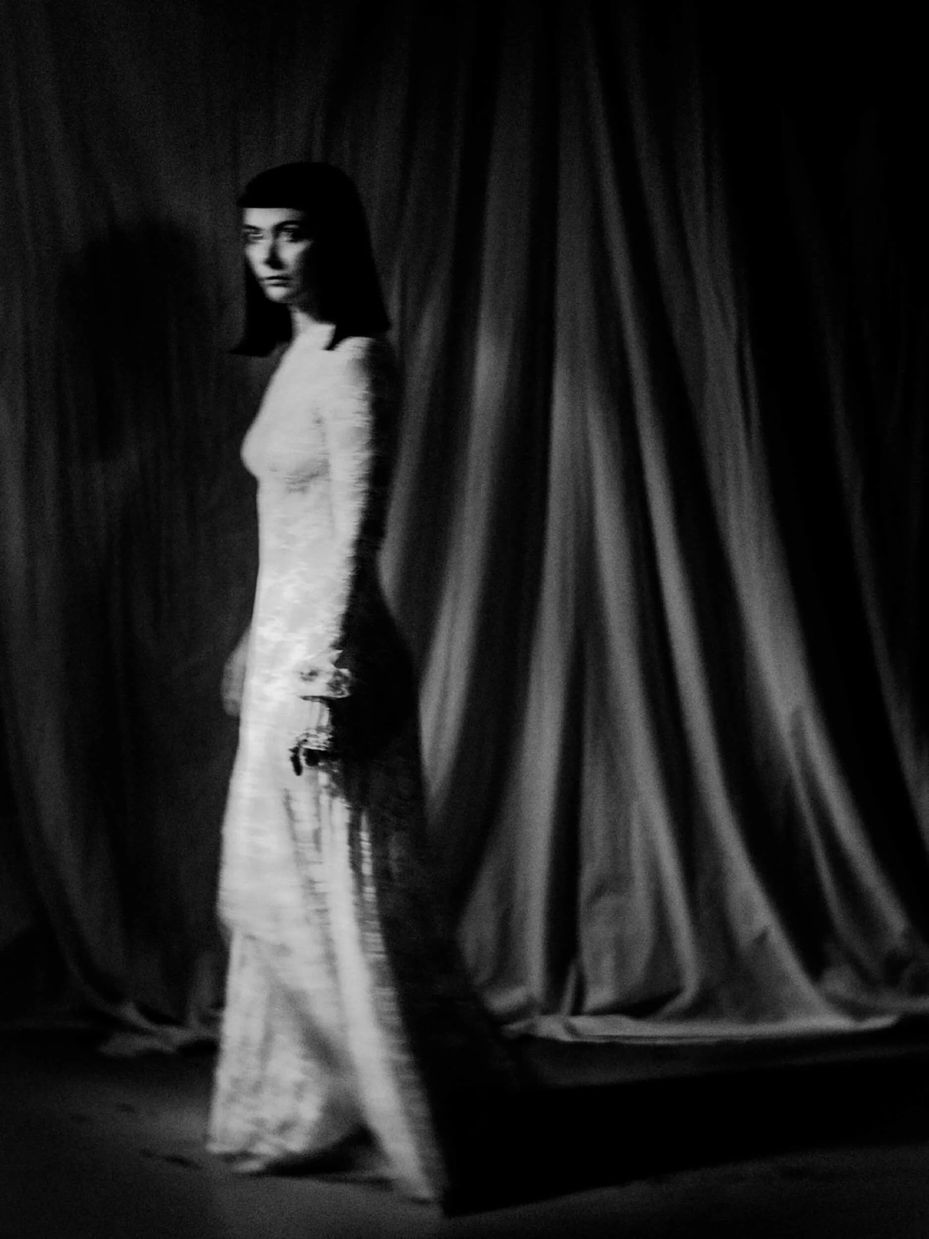 Parker J Pfister Fine Art Portrait of Black and White image of white woman standing in a long gown looking sideways at camera
