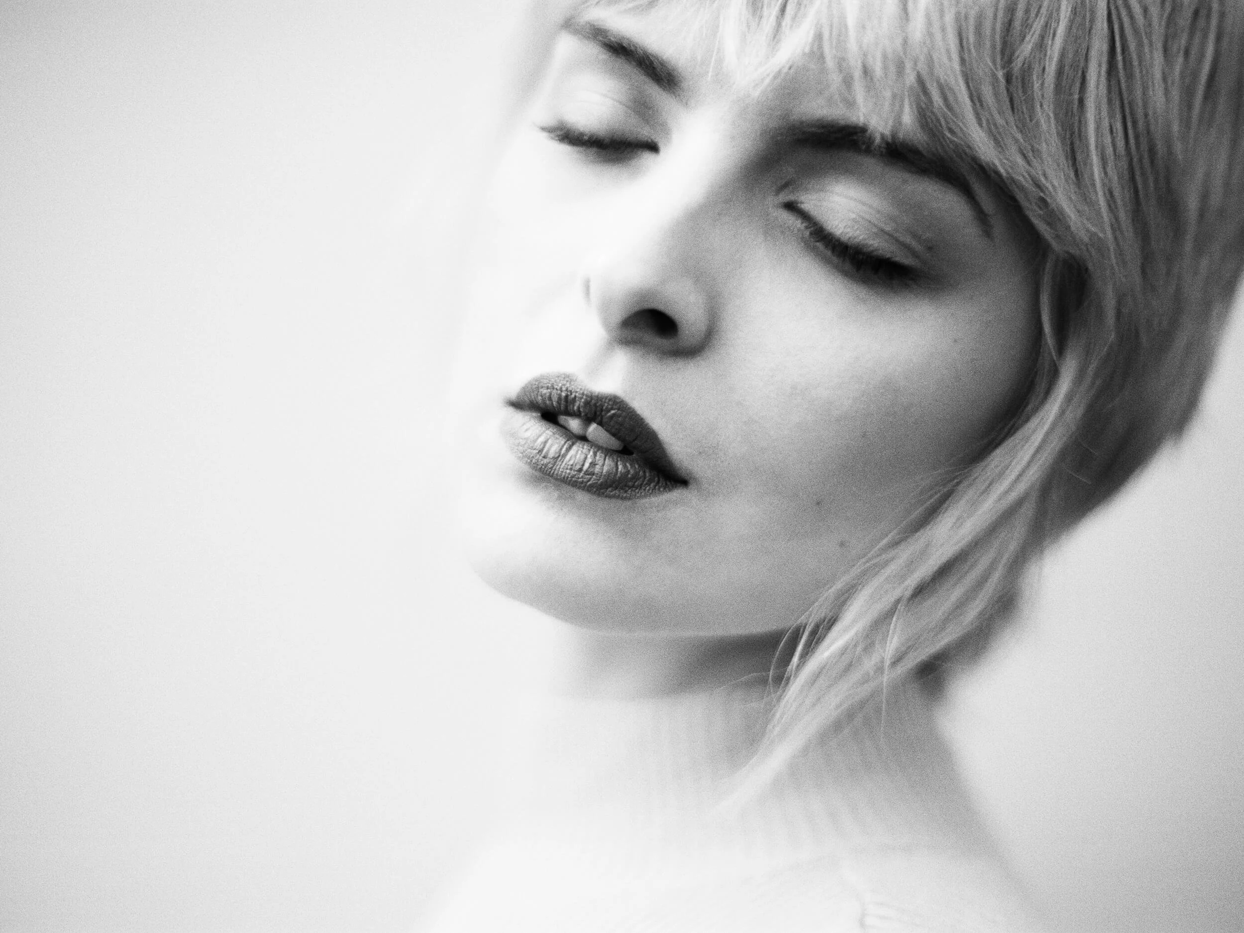 Parker J Pfister Fine Art Black and White Photography of a white woman's head faced sideways towards the camera with her eyes closed.