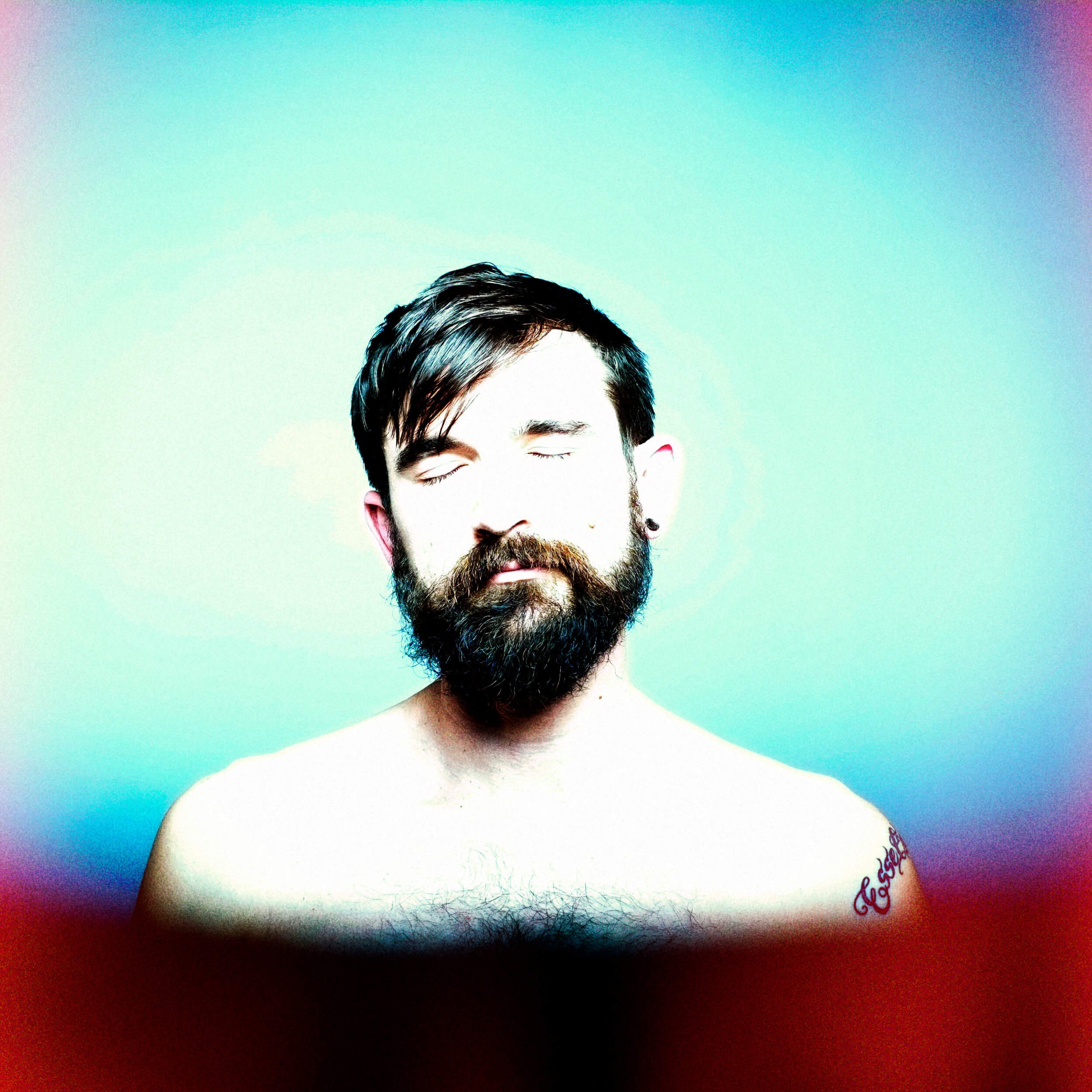 Parker J Pfister Fine Art Portrait of a white man with a beard and no shirt facing the camera with his eyes closed.