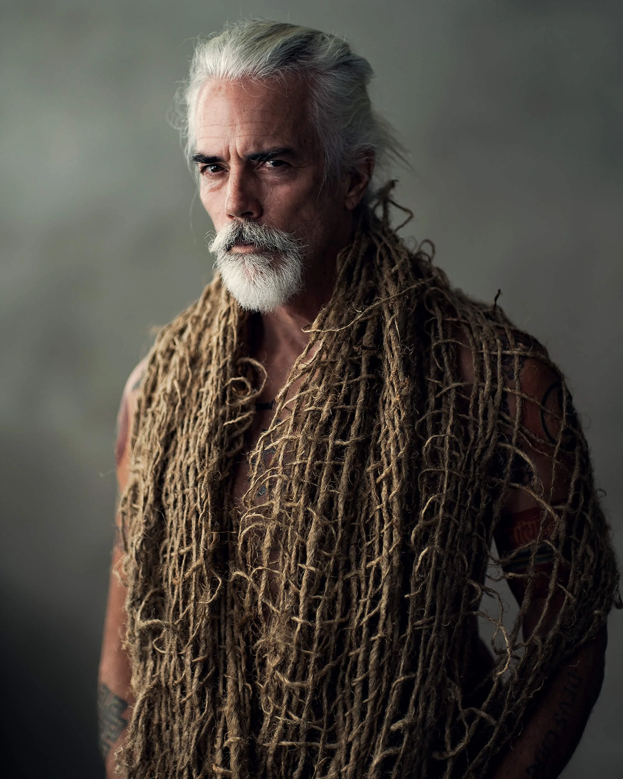 Parker J Pfister Fine Art Portrait of an older white man with a beard with a large hemp net wrapped across his shoulders. 