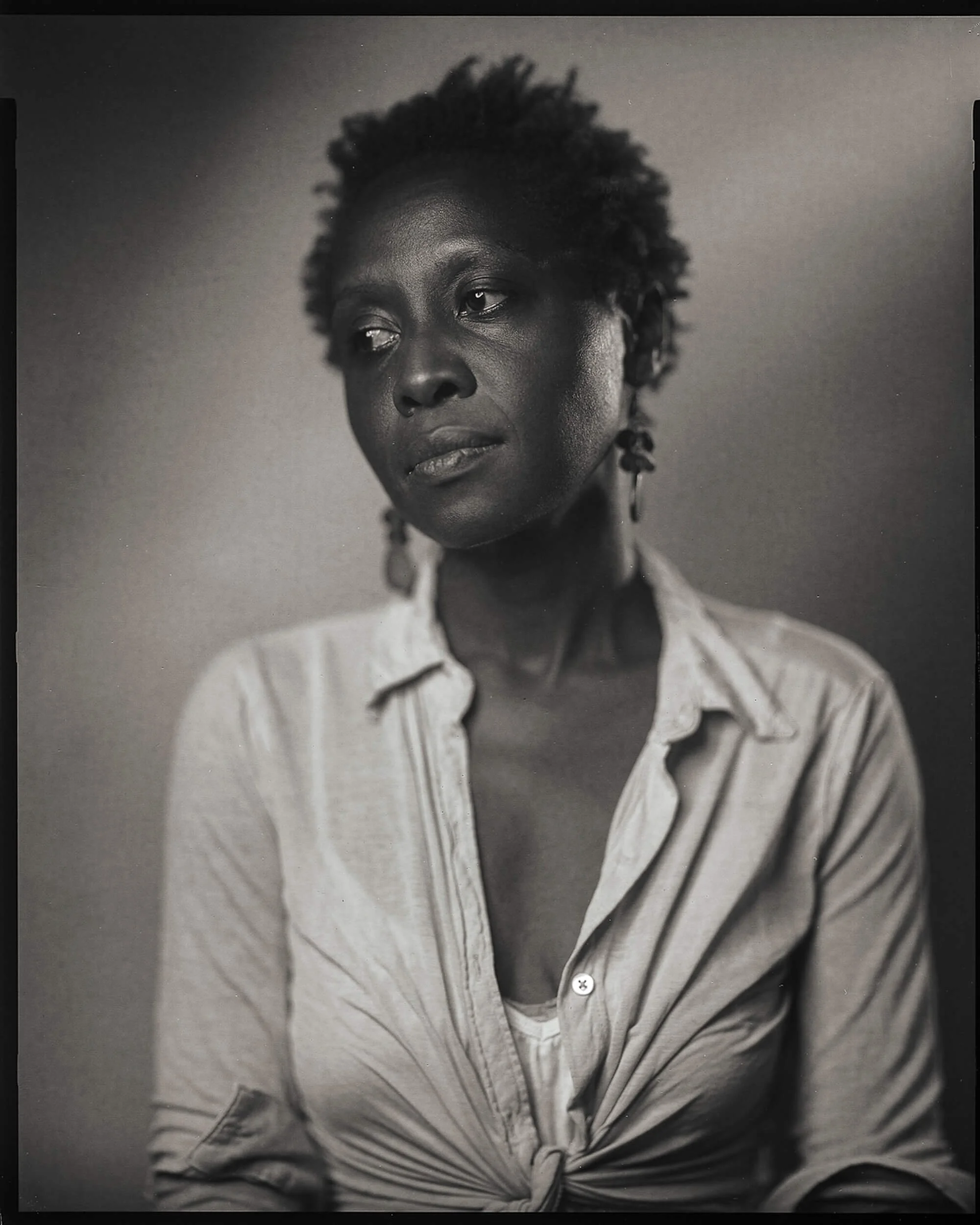Parker J Pfister Fine Art Black and White Photography of a black woman with short hair looking thoughtfully away from the camera.