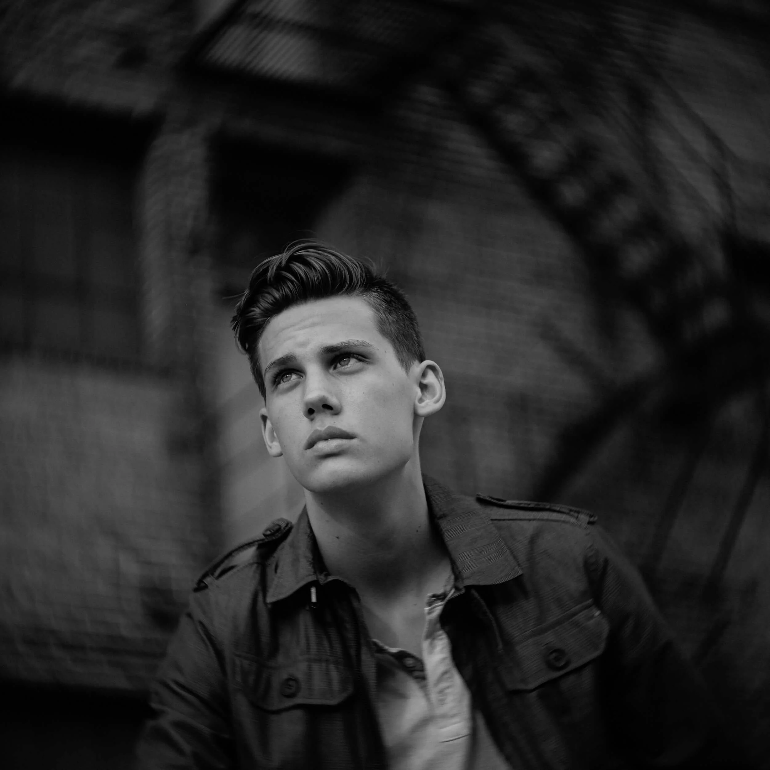 Parker J Pfister Fine Art Black and White Photography of a young white male wearing a jacket looking up and away. 