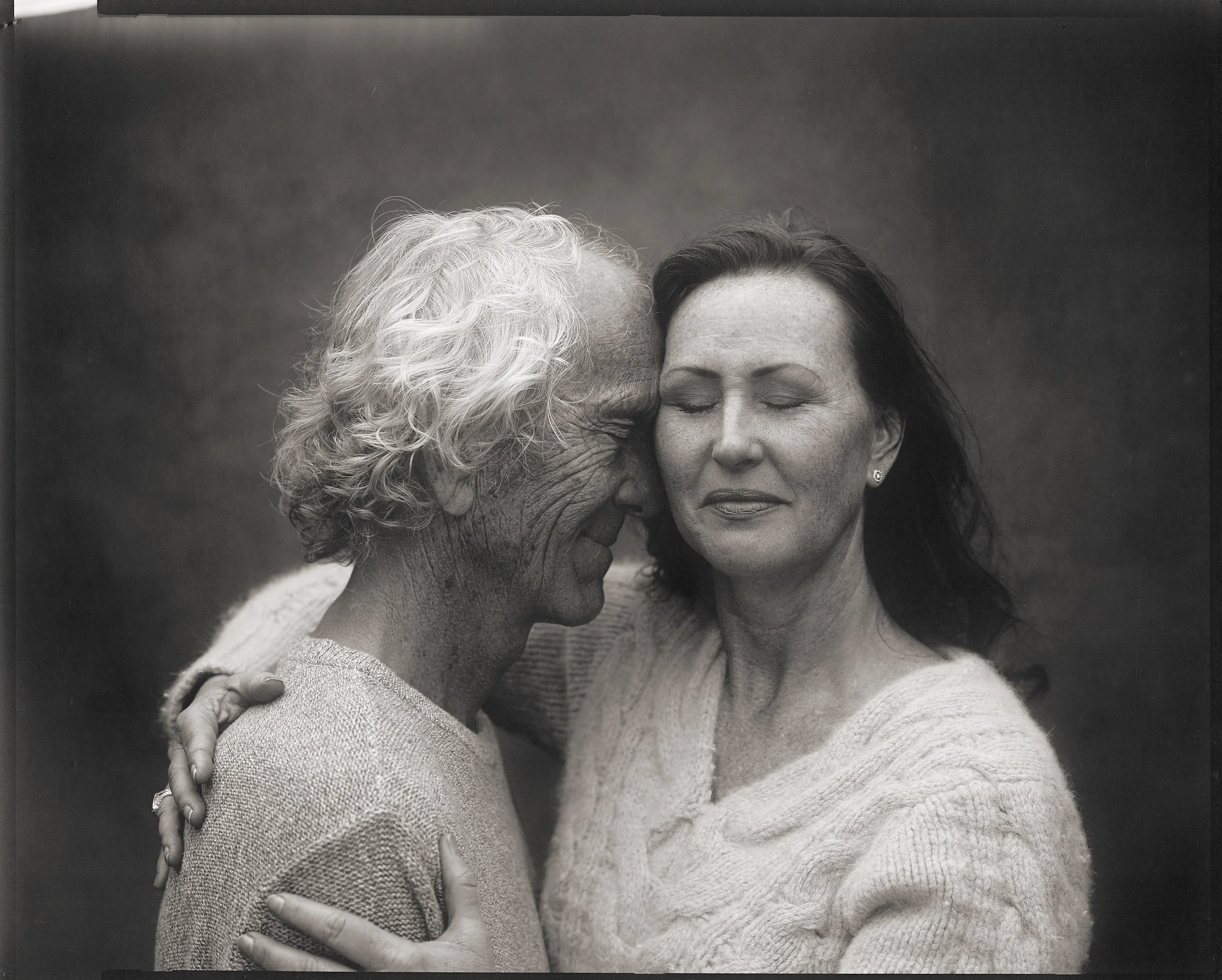 Parker J Pfister Fine Art Black and White Photography of two older people embracing each other in feeling of security and love. 