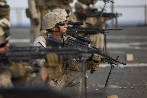 Soldiers in combat gear aiming rifles during training or deployment.