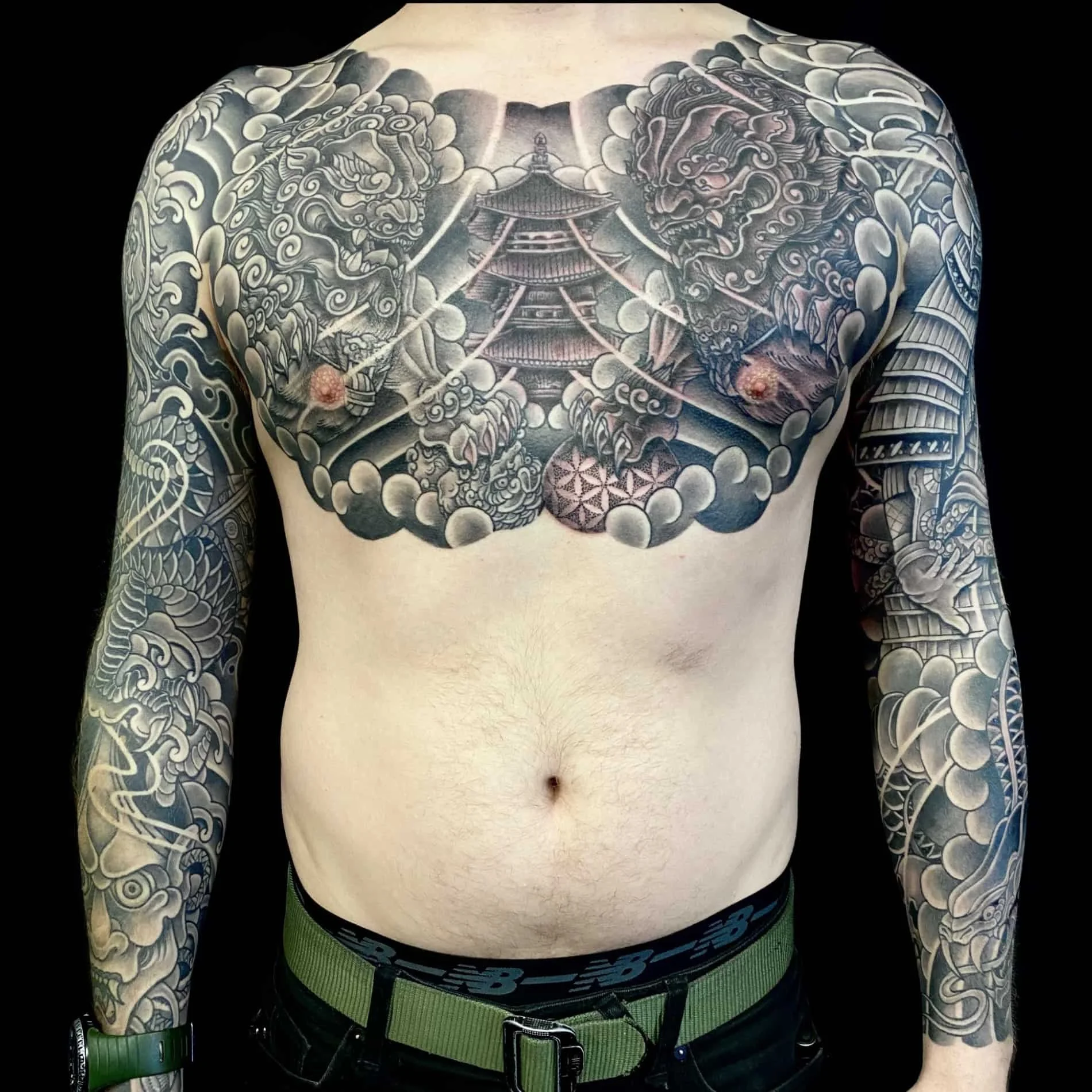 Japanese tattoos consisting of two full sleeves as well as a chest piece.  Fudogs, water, warriors, and various other elements created this large scale black and grey tattoo.