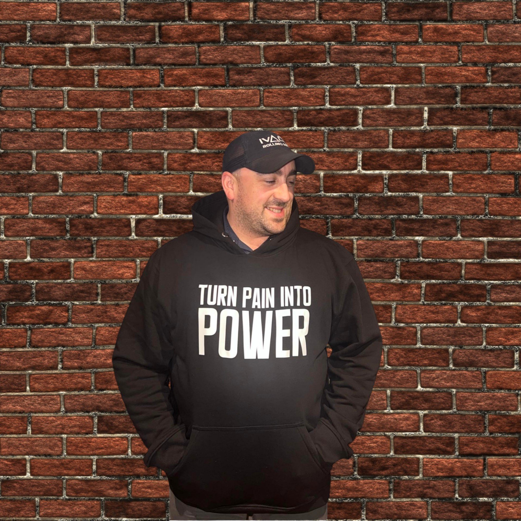 sean wearing turn pain into power hoodie brick background-Photoroom.jpg