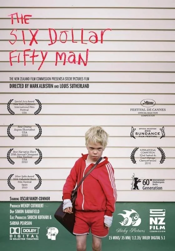 Movie poster for 'The Six Dollar Fifty Man,' directed by Mark Albiston and Louis Sutherland. Features a young boy in a red tracksuit with a serious expression, holding a bag, standing in front of a white wall with various film festival awards and acknowledgments.
